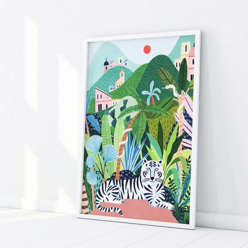 May include: A white tiger with black stripes is lying down in a lush green jungle setting. The tiger is surrounded by palm trees, ferns, and other tropical plants. There are buildings in the background, suggesting a city or town.