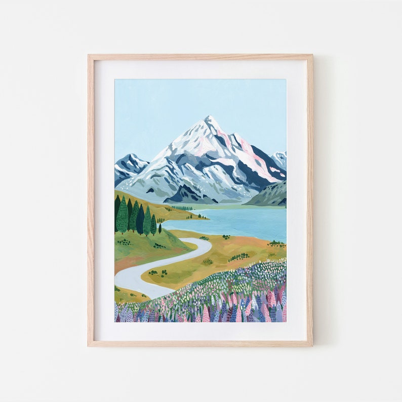 Puede incluir: Una pintura de una cordillera con un pico nevado, un camino sinuoso que lleva a un lago y un campo de flores moradas en primer plano.