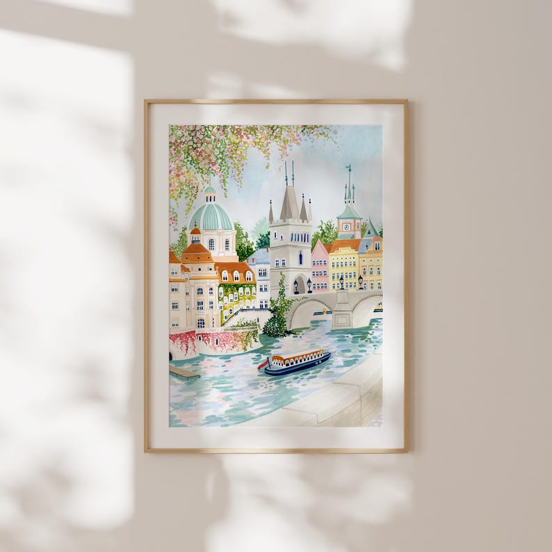 May include: Watercolor painting of a cityscape with a bridge over a river. The buildings are colorful and have a whimsical style. There are trees and flowers in the foreground. A small boat is in the river.
