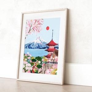 May include: A framed illustration of Mount Fuji with a red pagoda in the foreground. The mountain is snow-capped and the pagoda has a red roof and white walls. There are pink cherry blossoms in the trees and a red sun in the sky.