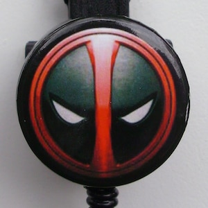 May include: A black retractable badge holder with a red and black Deadpool character design.