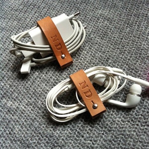 Two customized charger / earphone cord organizer in leather. Made in France