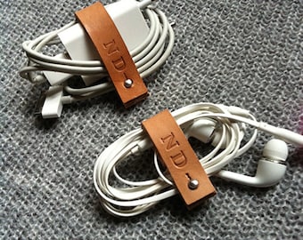 Two customized charger / earphone cord organizer in leather. Made in France