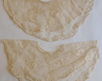 Puede incluir: Dos delicados cuellos de encaje blanco con bordados florales. Los cuellos son festoneados y tienen un diseño delicado y femenino.