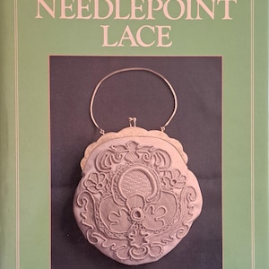 May include: A book cover with the title "Introduction to NEEDLEPOINT LACE" in pink script. The cover features a detailed image of a cream-colored, ornate needlepoint lace purse with a silver handle. The author's name, NENIA LOVESEY, is printed at the bottom.