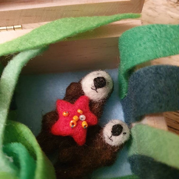 Needle felted otter mother and pup in a box