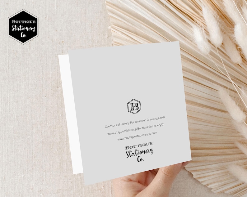 May include: A white card with a gray background and black text. The text reads "Boutique Stationery Co." and includes the company's website address and a logo with the letter "B".