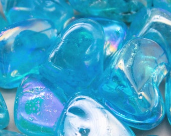 May include: A group of iridescent blue heart-shaped crystals. The crystals are smooth and translucent, with a slight shimmer.