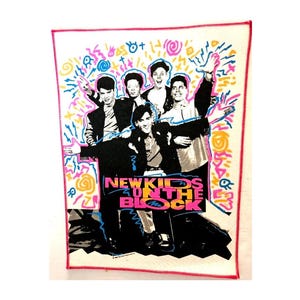 Könnte beinhalten: Ein rechteckiger Stoffaufnäher mit einem schwarz-weißen Foto der Musikgruppe New Kids on the Block. Das Design enthält neonfarbene pinke, gelbe und blaue abstrakte Schnörkel und Formen sowie den Schriftzug NEW KIDS ON THE BLOCK in Pink.