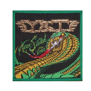 May include: A black and green embroidered patch featuring a gold snake and the text "Y&T" and "Heavy Streak Tour".