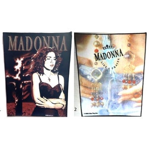 May include: Two vintage Madonna iron-on patches. The first patch features a black and white image of Madonna with the word "Madonna" in gold lettering. The second patch features a colorful image of Madonna with the words "Madonna Like a Prayer" in gold lettering.