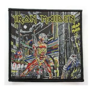 May include: Iron Maiden band logo patch with a black background and a colourful image of a man with a red and yellow body, standing in a city street with buildings and street signs. The text "Iron Maiden" is in white letters above the image.