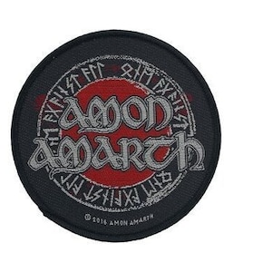 May include: Amon Amarth band logo patch featuring a red circle and silver lettering. The circle is surrounded by a black background with silver runes.