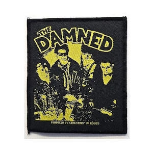 May include: Black square patch featuring a yellow and black graphic of a band with the text "THE DAMNED" at the top. The band members are in silhouette, with the text "PRODUCED BY CEREMONY OF ROSES" at the bottom.