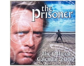 May include: A 2002 calendar featuring the TV show "The Prisoner". The cover features a close-up of Patrick McGoohan's face with a superimposed image of a bicycle wheel. The background shows a man walking away on a beach with a blue sky and clouds.