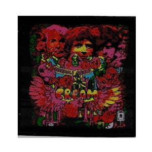 May include: A black and white patch with a psychedelic design featuring three faces, flowers, and the word "CREAM".