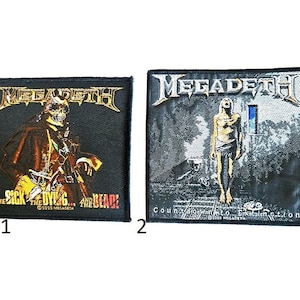 May include: Two black patches featuring the band name "Megadeth" in a silver, gothic font. One patch displays a grim reaper figure with the text "The Sick, The Dying... And The Dead!". The other patch shows a figure with the text "Countdown to Extinction".