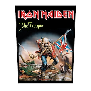 Peut inclure: Un patch noir et blanc avec le texte "Iron Maiden" et "The Trooper" en jaune. L'image représente une figure squelettique en uniforme rouge et bleu tenant un drapeau britannique et une épée, courant vers le spectateur.