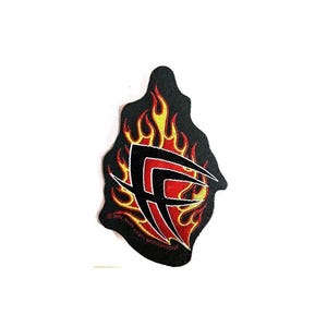 May include: Black patch with a red and yellow flame design. The patch features a stylized letter "F" in red with black outlines. The flames are outlined in yellow and red, creating a fiery effect. The patch is likely for clothing or accessories.