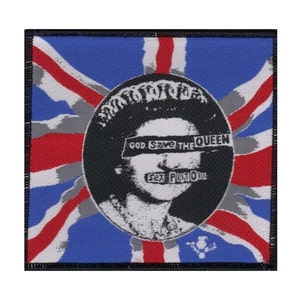 May include: A black and white image of Queen Elizabeth II with the words "God Save The Queen" and "Sex Pistols" superimposed over her face. The image is set against a red, white, and blue Union Jack flag.