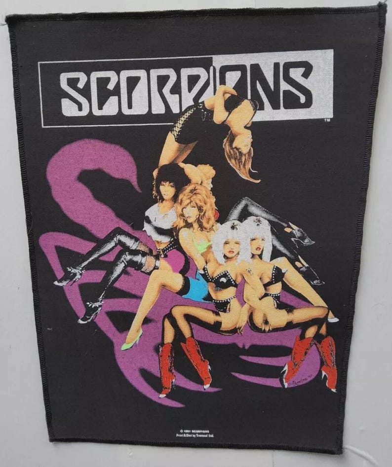 May include: Black patch with the band name "SCORPIONS" in white. The image shows several women in various poses, with a large purple scorpion graphic behind them. The women are wearing black and colorful outfits.