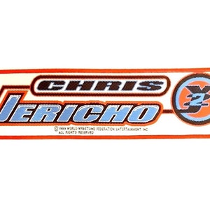 May include: A white rectangular patch with an orange border. The patch features the text "CHRIS JERICHO" in black and blue lettering with a stylized "Y2" logo in a blue circle with an orange center.