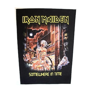 May include: Black and yellow embroidered patch featuring the band Iron Maiden with the album title "Somewhere in Time". The patch depicts a futuristic cityscape with a skeletal figure holding a gun.