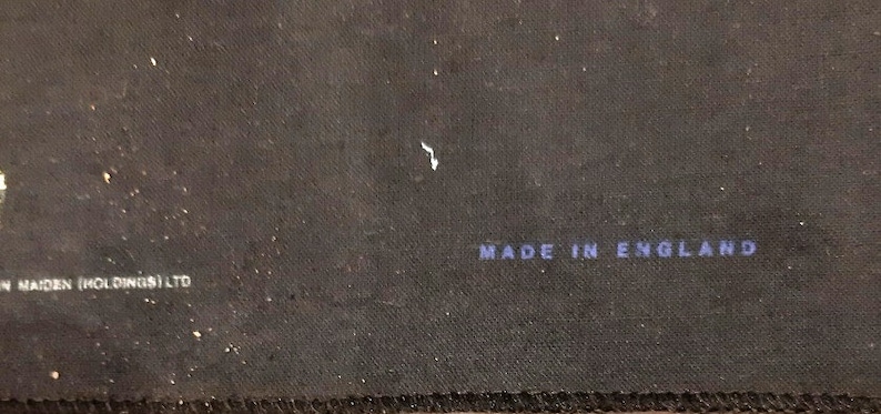 May include: Close-up of a black fabric surface with the text "Made in England" printed in blue.