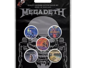 May include: A set of six Megadeth button badges featuring album art from various albums. The badges are displayed on a black background with a skull graphic. The text "QUALITY LICENSED BUTTON BADGE SET MADE IN ENGLAND MEGADETH" is printed on the top of the card.