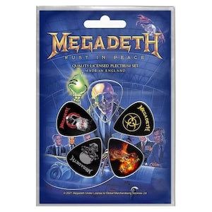 May include: A pack of four black guitar picks with different Megadeth designs. The picks feature the band's logo, a skull, and a biohazard symbol. The pack is labelled "Megadeth Rust in Peace Quality Licensed Plectrum Set Made in England".