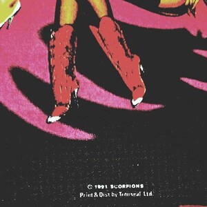 May include: A vintage graphic featuring red high-heeled boots with white tips, set against a pink and black background. The image includes text at the bottom: "&copy; 1991 SCORPIONS Print & Dist by Tenuseal Ltd."