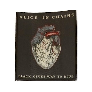May include: Black and white embroidered patch with a red heart and the text "Alice in Chains" and "Black Gives Way to Blue".
