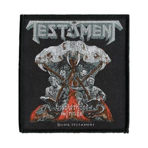May include: Black square patch featuring the band name "TESTAMENT" in silver lettering above a detailed graphic. The graphic depicts figures with crossed staffs, a skull-like structure, and the text "Brotherhood of the Snake". The patch includes the copyright year.