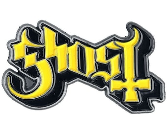May include: A black and yellow enamel pin with the word "Ghost" in a gothic font. The pin has a silver outline and a cross symbol at the bottom of the letter "t".