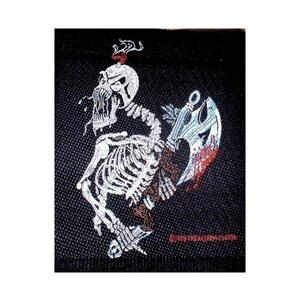 May include: A black embroidered patch featuring a white skeleton holding a bloody axe. The skeleton has a skull with a red flame on top of its head.