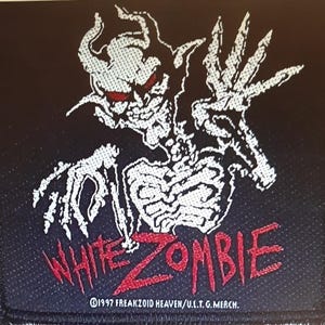 May include: A black and white patch featuring a white skeletal demon with red eyes and the text "White Zombie" in red letters. The text "©1997 FREAKZOID HEAVEN/U.L.T.G. MERCH." is in white letters at the bottom of the patch.