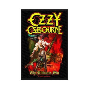 Peut inclure: Un écusson noir avec le texte "Ozzy Osbourne" en jaune et rouge, au-dessus d'une illustration d'une figure avec un démon. Le texte "The Ultimate Sin" est en dessous. L'écusson date de 2020.