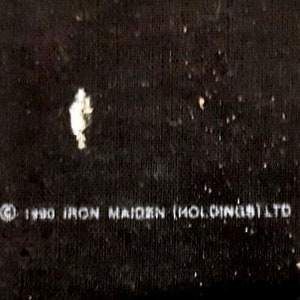 May include: Black and white text on a black background that reads "&copy; 1980 IRON MAIDEN (HOLDINGS) LTD"