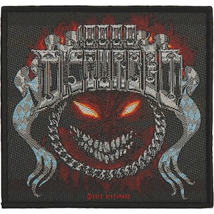 May include: A black square patch featuring a red, demonic face with glowing yellow eyes and a wide, toothy grin. The word "DISTURBED" is at the top. The design includes flames and a chain border. The text "©2012 DISTURBED" is at the bottom.