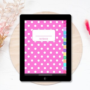 Könnte beinhalten: Ein rosa digitales Notizbuch mit weißen Punkten und einem weißen Etikett mit der Aufschrift "NOTEBOOK". Das Notizbuch hat eine Seitenleiste mit nummerierten Registerkarten in Regenbogenfarben.