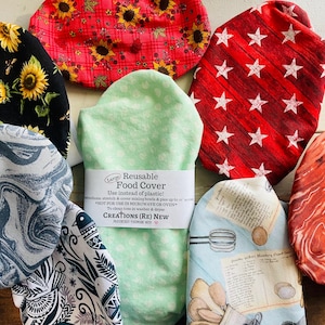 May include: A collection of reusable food covers in various patterns. Designs include sunflowers on black, red plaid with sunflowers, red with white stars, a light green cover with white polka dots, and others. The covers are designed to replace plastic wrap.