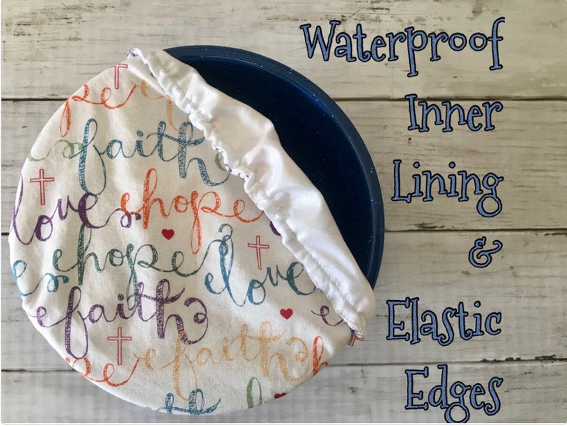 Reusable bowl cover in "Faith Hope Love" print: white fabric with elastic edges, featuring the words "faith, hope, love" in colorful script, along with cross and heart symbols. The cover is shown over a blue bowl, with text that reads "Waterproof Inner Lining & Elastic Edges."