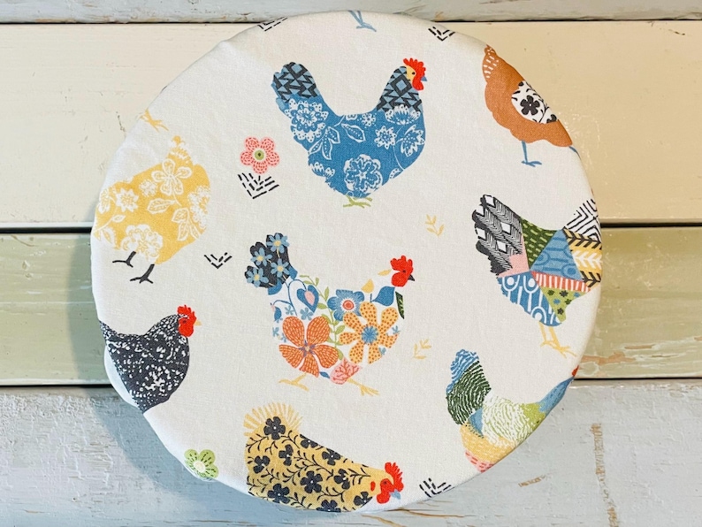 Reusable bowl covers in "Boho Chickens" print, featuring a repeating pattern of colorful chickens on a cream fabric. The chickens are decorated with floral and geometric designs in shades of blue, yellow, orange, and black.