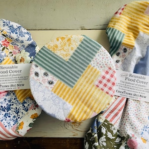 Reusable bowl cover in “Boho Patchwork” Print: various floral and striped patterns in shades of blue, yellow, red, and green.