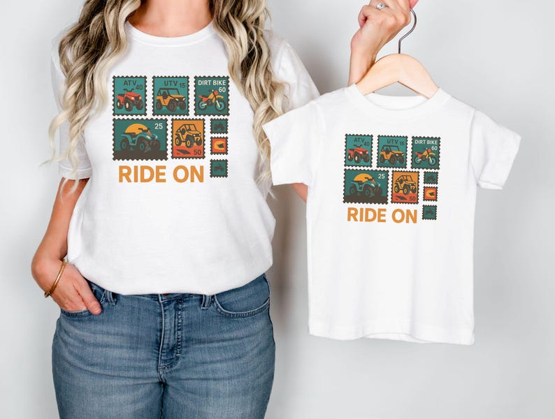May include: White t-shirts with a stamp-like design featuring ATVs, UTVs, and dirt bikes in red, yellow, and orange. The text "RIDE ON" is printed below the stamps. One shirt is adult size, the other is child size.
