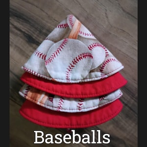 May include: A stack of three baseball-themed fabric items. The top two layers feature a baseball print with red stitching on a white background. The bottom two layers are solid red. The word "Baseballs" is printed at the bottom.