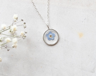 Handmade silver forget me not resin circle pendant with a real blue preserved flower