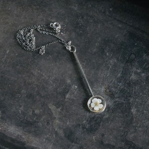 Long elegant vertical stick pendant for women in a gothic style with a dried pressed flower
