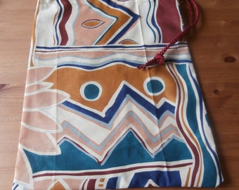 Abstract print drawstring bag with burgundy ties.