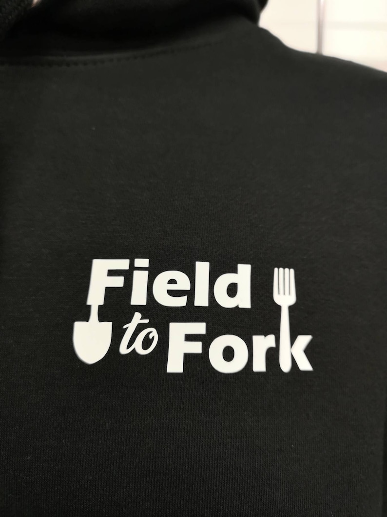 May include: Black hoodie with a white graphic that says "Field to Fork" with a shovel and fork icon.